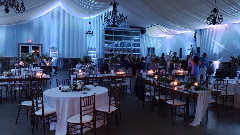 Elegant indoor wedding reception with dim lighting, floral centerpieces, and candlelit tables at a venue near Palm Beach, Florida.