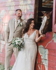 Palm Beach wedding venue engaged couple feeding horse in barn on beautiful ranch venue